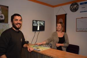 a man and a woman standing behind a counter at The Bug Backpackers in Nelson