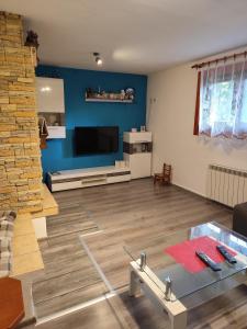 een woonkamer met blauwe muren en een glazen tafel bij Chalúpka Paci in Ždiar +21 foto's