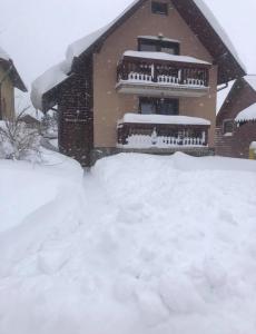 een huis met een berg sneeuw ervoor bij Chalúpka Paci in Ždiar