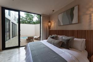 una camera da letto con un letto grande e una grande finestra di Oniric Condo Tulum a Tulum Altre 291 foto