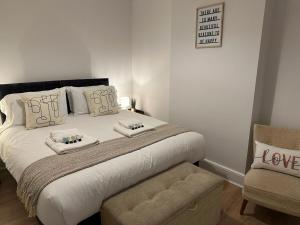 a bedroom with a bed with two pillows and a chair at 3 Bed Chill Glouc Free Parking in Gloucester