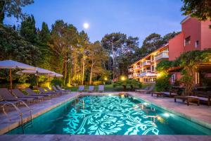 a swimming pool with chairs and a building at Barradas Parque Hotel & Spa in Punta del Este