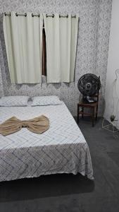 Aconchego da cris في لينكويس: غرفة نوم بسرير ونافذة مع ستائر