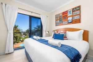 a bedroom with a large bed and a large window at Gordons Village View in Gordonʼs Bay +28 photos