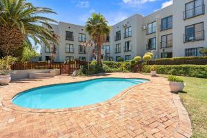 a swimming pool in front of a building at Gordons Village View in Gordonʼs Bay