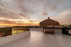 a roof top with a gazebo and a sunset at Shukty Villa Pandawa in Ungasan