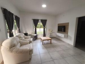 un soggiorno con due divani bianchi e una TV di LA VENTURA, Azul ad Azul