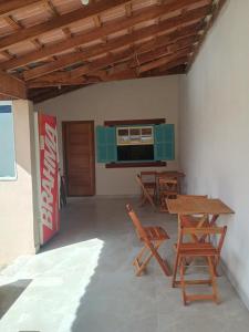 una stanza con sedie, tavolo e televisore di Espaço Dtalia a Piedade