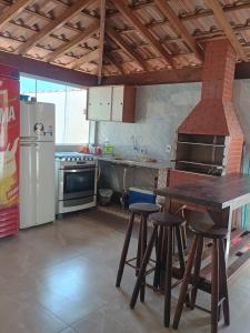 a kitchen with a table and some stools in it at Espaço Dtalia in Piedade