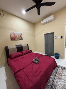 Schlafzimmer mit einem roten Bett und einem Deckenventilator in der Unterkunft Welcome To Amda CS Guest House  + 2 Fotos