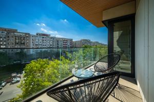 a balcony with two chairs and a table at Best Residence - High-End Suites - by Solinis Homes in Bucharest