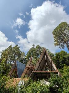 een huis met een dak met bomen op de achtergrond bij the jungle book - luxury camps by lake & woods in Bhīm Tāl