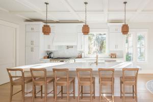 a kitchen with a large white island with wooden chairs at 3151 Baywood Drive in Seabrook Island +40 photos