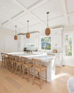 a kitchen with white cabinets and a large island with chairs at 3151 Baywood Drive in Seabrook Island