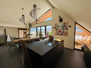 a kitchen with a large island in a room with windows at Alpen Sky Suite Flachau in Flachau