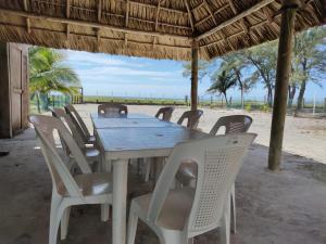 a wooden table and chairs under a wooden umbrella at Casa Playa Linda VILLA LUA Tapachula in El Desengaño
