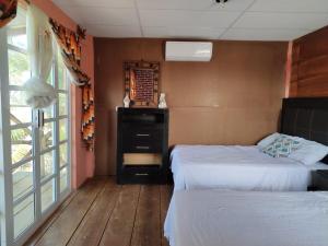 a bedroom with two beds and a window at Casa Playa Linda VILLA LUA Tapachula in El Desengaño