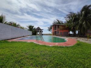 a swimming pool with a slide in the middle of a yard at Casa Playa Linda VILLA LUA Tapachula in El Desengaño