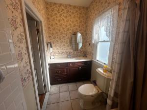 ein Badezimmer mit Toilette, Waschbecken und Spiegel in der Unterkunft Beauclaires Bed & Breakfast in Cape May + 67 Fotos