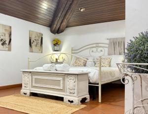 a bedroom with a white bed and a table with towels at Villa Meraville B&B in Bologna