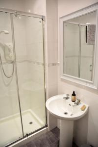 een witte badkamer met douche en wastafel bij Govandale Seaviews in Kingarth +6 foto's