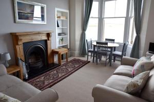 een woonkamer met een bank en een open haard bij Govandale Seaviews in Kingarth