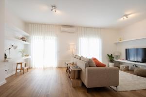 a living room with a couch and a tv at Bright & Spacious Villa by Beach in Ribeira Grande