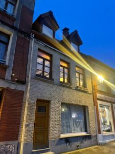 a brick building with windows and a door at Aux cieux enchanteurs maison magique et spa in Hondschoote