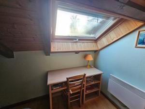 a room with a desk with a window and a chair at appartement le petit chalet sauna in La Bresse