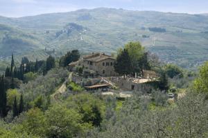 ein altes Haus auf einem Hügel in einem Tal in der Unterkunft Agriturismo La Camporena in Greve in Chianti