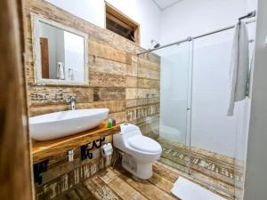 um banheiro com pia, vaso sanitário e chuveiro em Hotel Cattaleya em Cali mais 25 fotografias