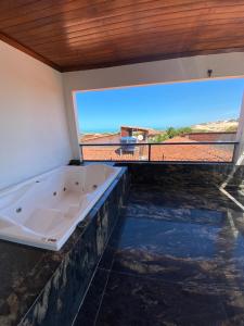 una vasca da bagno in una stanza con una grande finestra di Canoa Suites & Apartments a Canoa Quebrada Altre 101 foto