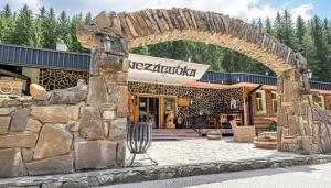 een toegang tot een gebouw met een stenen muur bij Apartmán Stella, Vysoké Tatry in Tatranska Strba