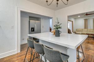 eine Küche und ein Wohnzimmer mit einer weißen Theke und Stühlen in der Unterkunft Walk to Marshall University Home with Private Yard! in Huntington