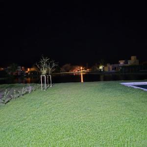 ein großes, grasbewachsenes Feld bei Nacht neben dem Wasser in der Unterkunft Casa solares del carcaraña in Maciel