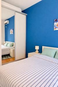 a blue bedroom with a bed and a mirror at One-Bedroom Apartment with Terrace, Sea View, Pool and Spa Lavender Bay Morinj in Donji Morinj +15 photos