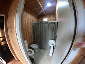 a small bathroom with a toilet and a shower at Cabañas Natural Box 2 in Victoria