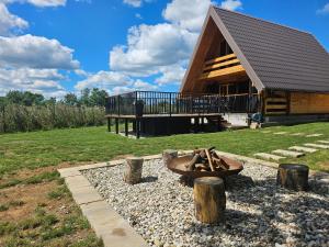 a fire pit in front of a log cabin at Tomina Koliba Lika in Sveti Rok +24 photos