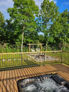 a hot tub on a deck with a fence at Tomina Koliba Lika in Sveti Rok