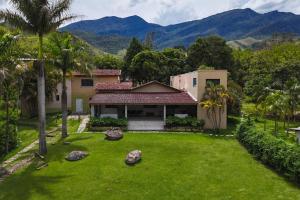 a house with a yard with rocks in front of it at Recanto Bamboo in Lavrinhas