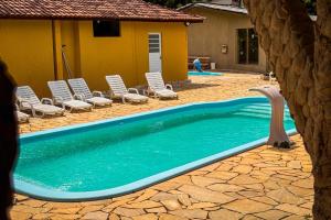 a swimming pool with lounge chairs and a swimming pool at Recanto Bamboo in Lavrinhas