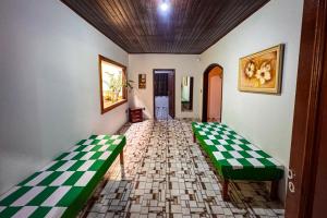 two green benches in a room with checkered floors at Recanto Bamboo in Lavrinhas