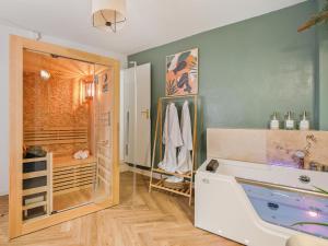 un bagno con vasca e doccia di L'Evasion Tropicale - idéal couple - sauna - baignoire balnéo LED - TV 4K Ambilight 130cm - parking gratuit à 2 pas du logement - wifi - maison médiévale sur 2 étages - entièrement rénovée 37m2 a Bargemon
