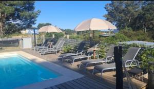 a group of chairs and umbrellas next to a swimming pool at Posada Bliss in Punta del Este