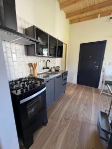 a kitchen with a black stove top oven at Posada Bliss in Punta del Este +13 photos