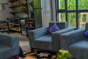 a living room with two chairs and a couch at Kinigi Cottage in Kinigi