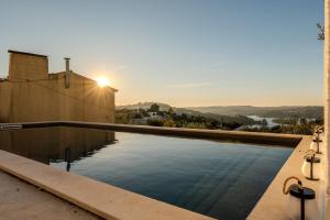 een zwembad met zonsondergang op de achtergrond bij Green House Zêzere 