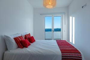 een slaapkamer met een bed met rode kussens en een raam bij Green House Zêzere  +41 foto's