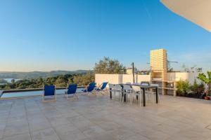 een terras met een tafel en stoelen op een dak bij Green House Zêzere 