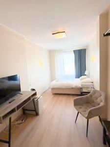 ein Zimmer mit zwei Betten und einem Schreibtisch und einem Fernseher in der Unterkunft Apartamenty Castello Kamilla in Kluczbork